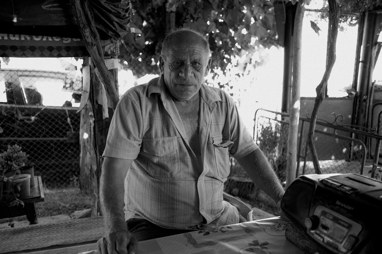 Black and white portrait of an elderly man outdoors in Bulgaria.