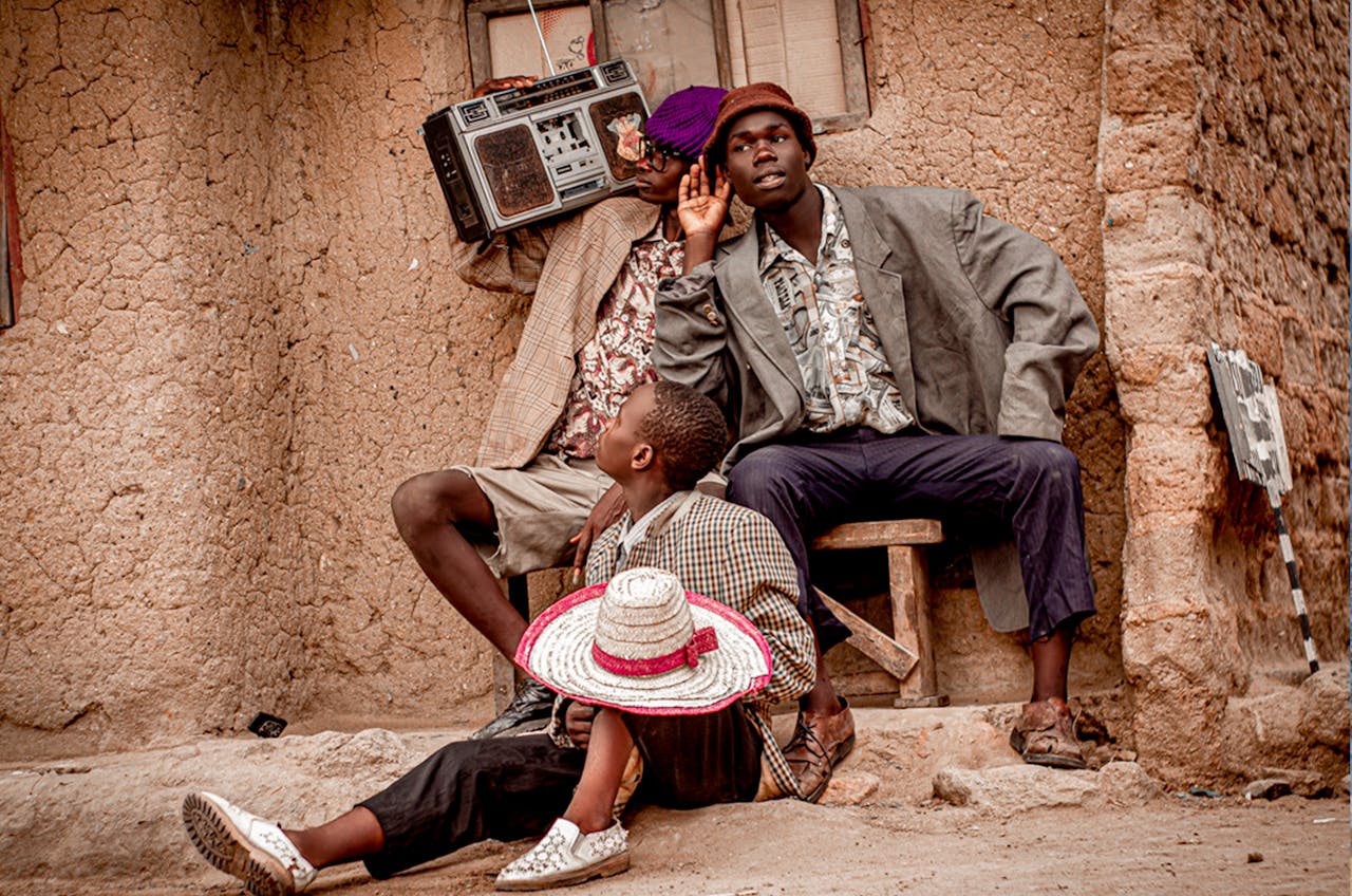 Three friends enjoying music outdoors in Blantyre, Malawi.